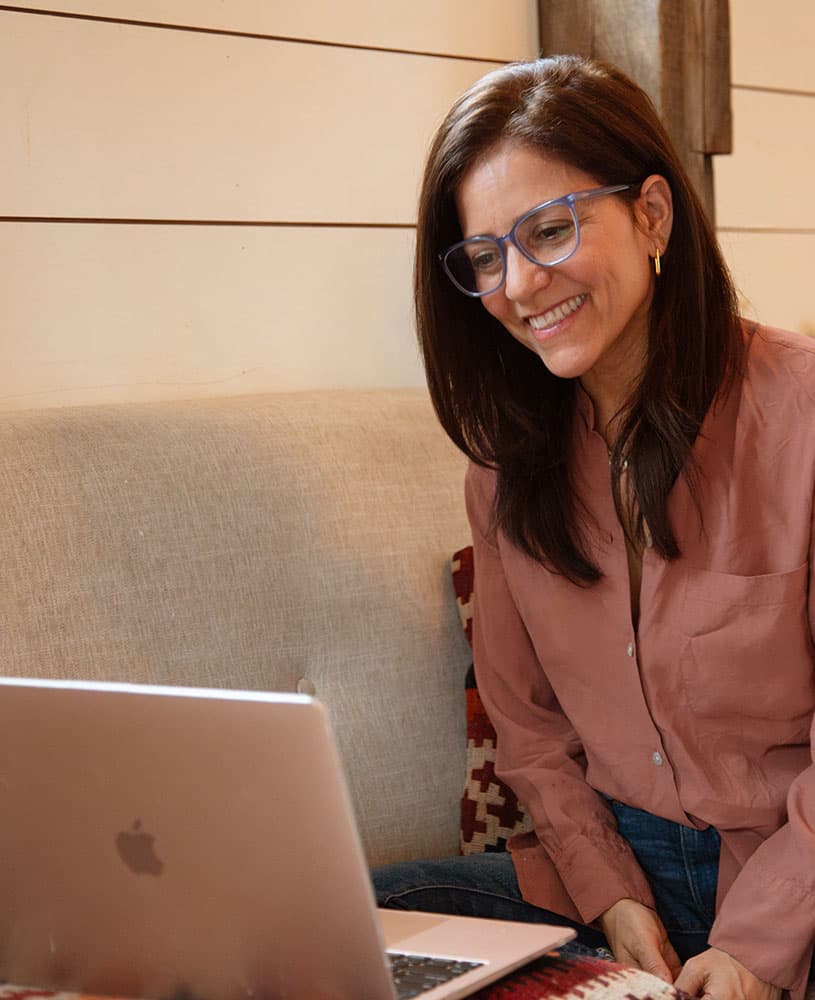 Lisa Weinert smiling at her laptop during a coaching session